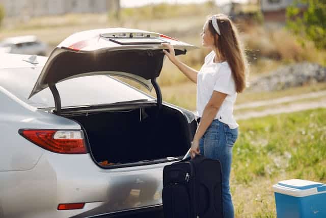 une voiture avec une femme et une glacière