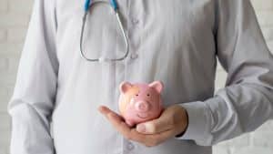 un médecin avec une tirelire dans la main