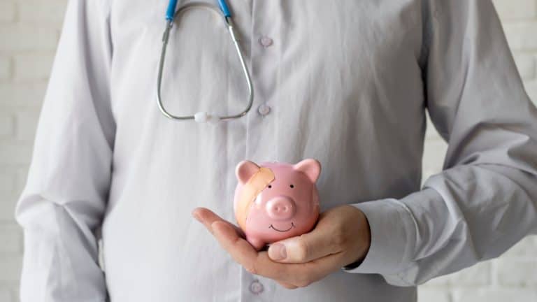 un médecin avec une tirelire dans la main